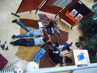 Jugendliche auf einer Decke beschäftigen sich mit Verhütungsmitteln