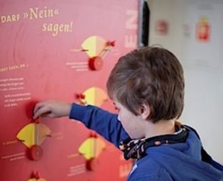 Echt Klasse ein Junge mit blauem Pulli spielt mit der Echt klasse ausstellung
